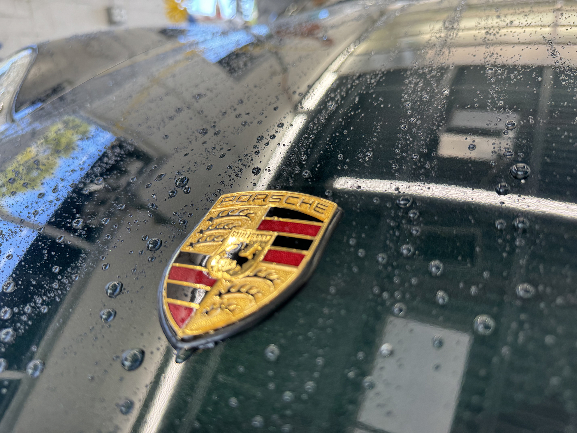 A close up of the Porsche logo after a car detailing at Clean Car Wash and Detail in Fredericksburg, VA.